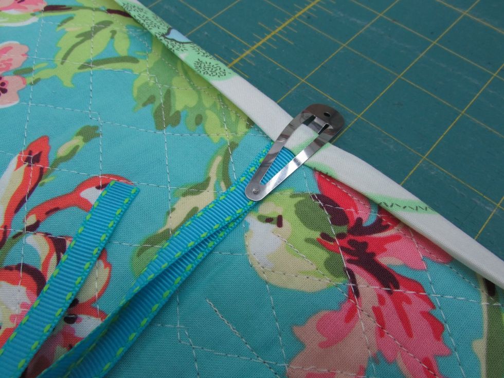 Tuck the ends of the ribbon ties into the outside flap under the edge trim. Use a clip or pin to secure it in place.