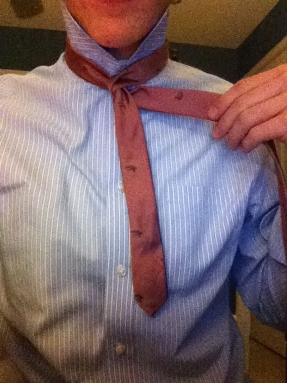 Tug the short, thin down a bit as you pass the long, fat piece behind it. The two pieces should be where they started, with the short, thin piece on your right/middle and the long piece on the left.