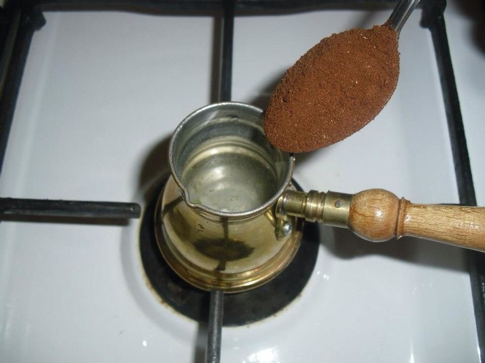 Turn down the heat and add the coffee , don't stir it yet , just let the coffee float on the surface .
