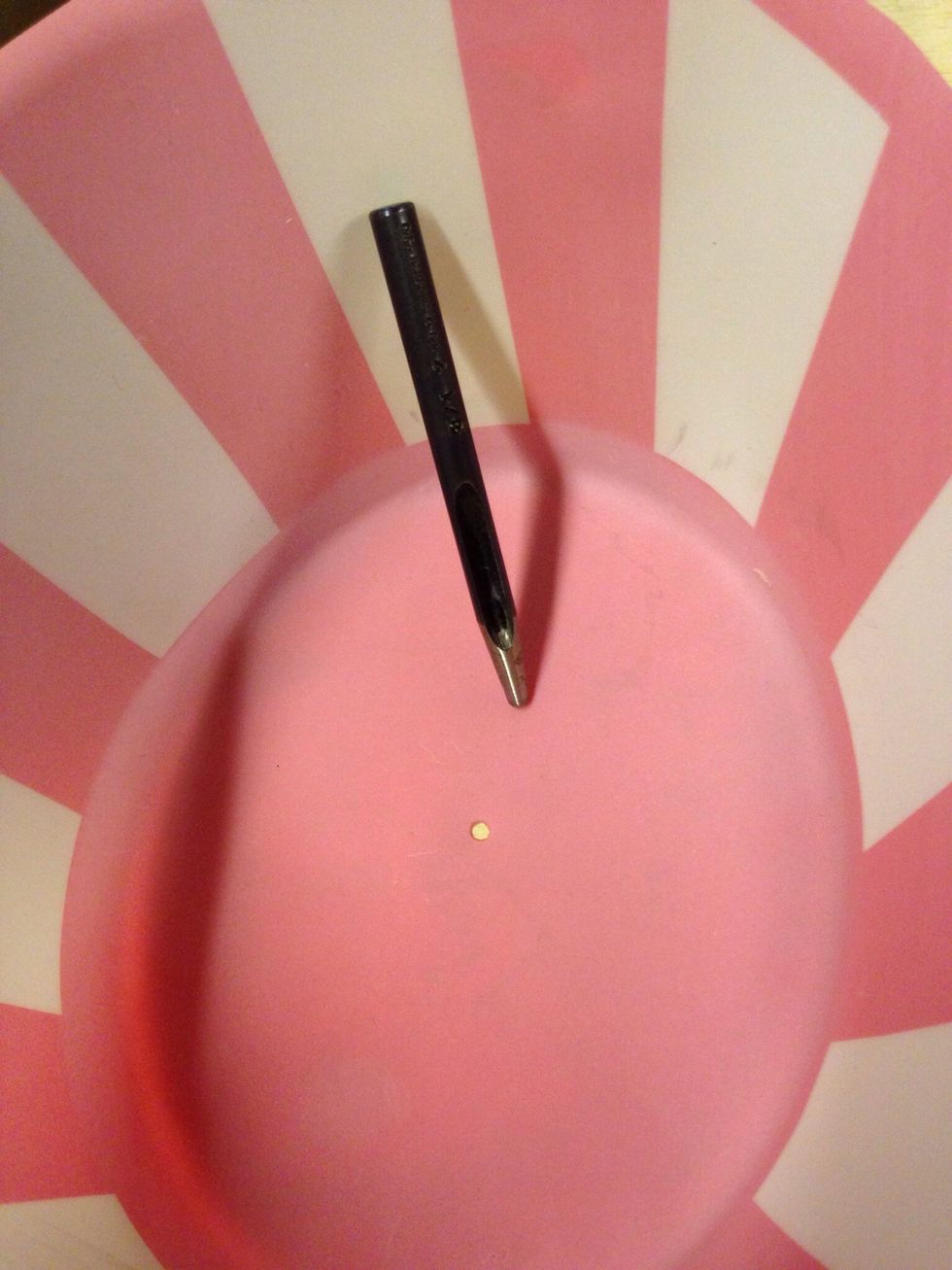 Turn hat upside down. Punch a hole inside the top of hat with the hammer and awl.
