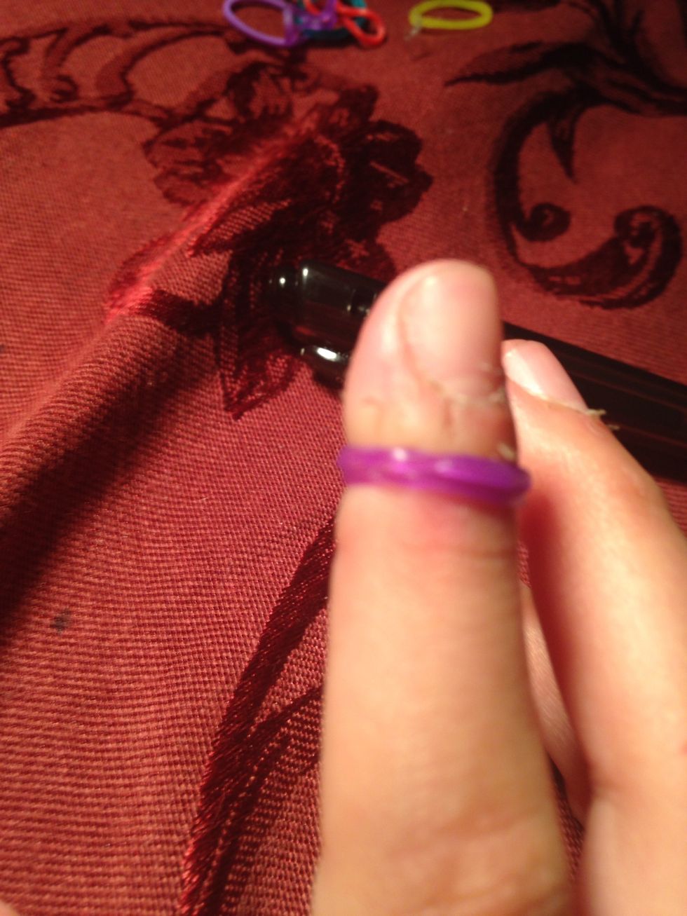 Turn it into an eight and put it on your finger then slide it on the pen