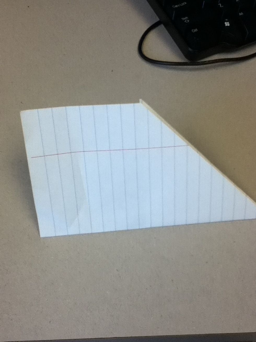 Turn it on its side and fold it in half to make it in the shape of an airplane