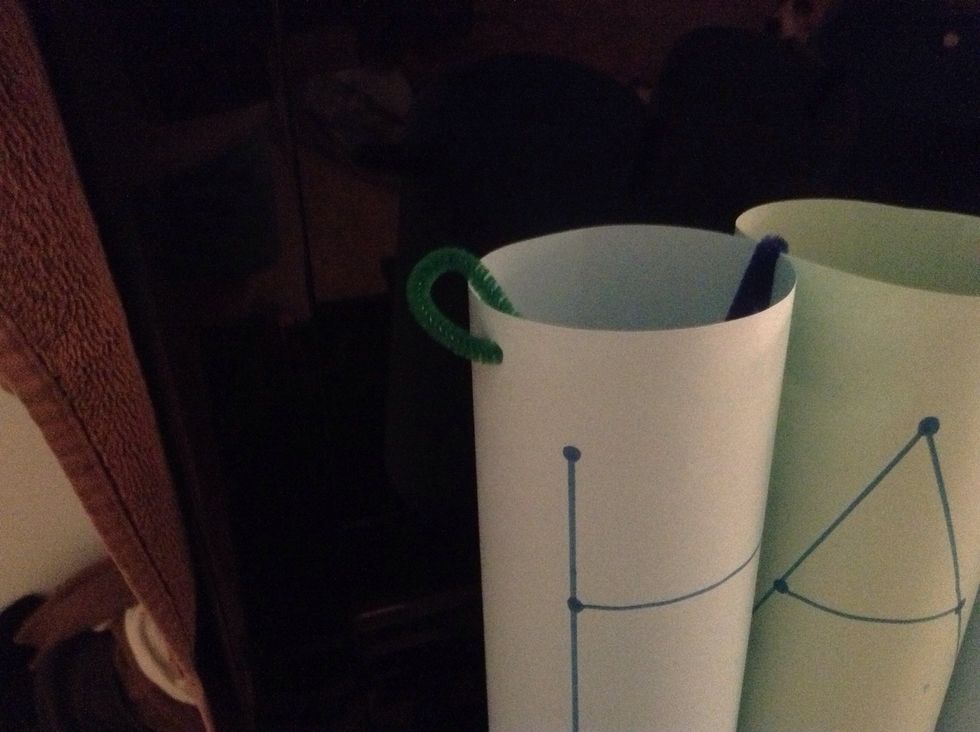 Turn it right side up and make a circle out of pipe cleaners. Loop it through the outside hole.