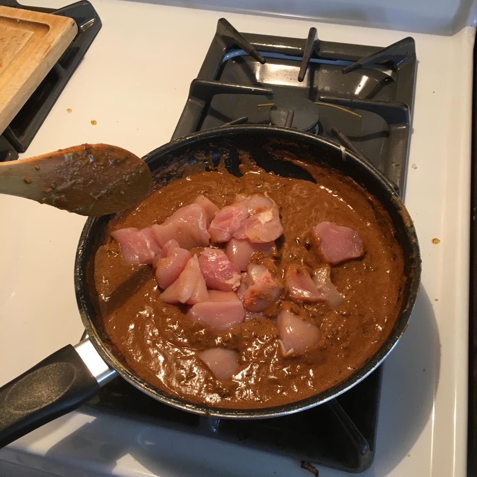 Turn off heat then place chicken breasts in curry.