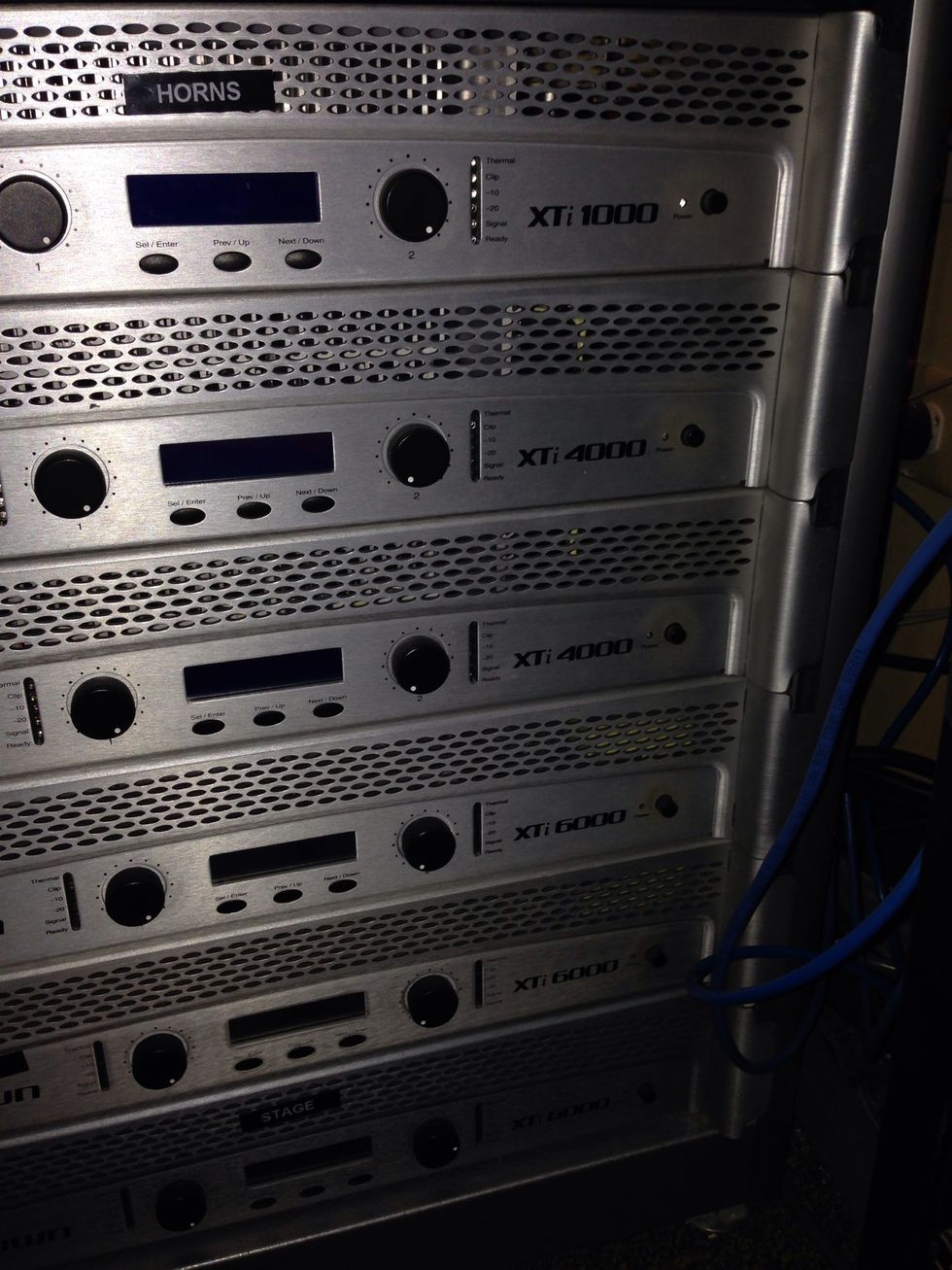 Turn on the power amps by pressing the small black button on the far right of each amp.