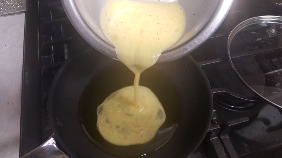 Turn on the stove, and gently pour the omelette mixture into the pan. Pour evenly, so that the thickness is the same throughout the surface.