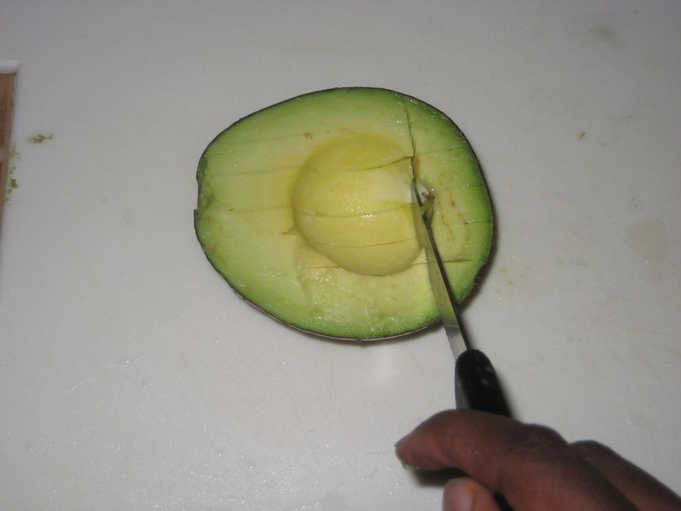 Turn the avocado and make parallel cuts across the fist ones.
