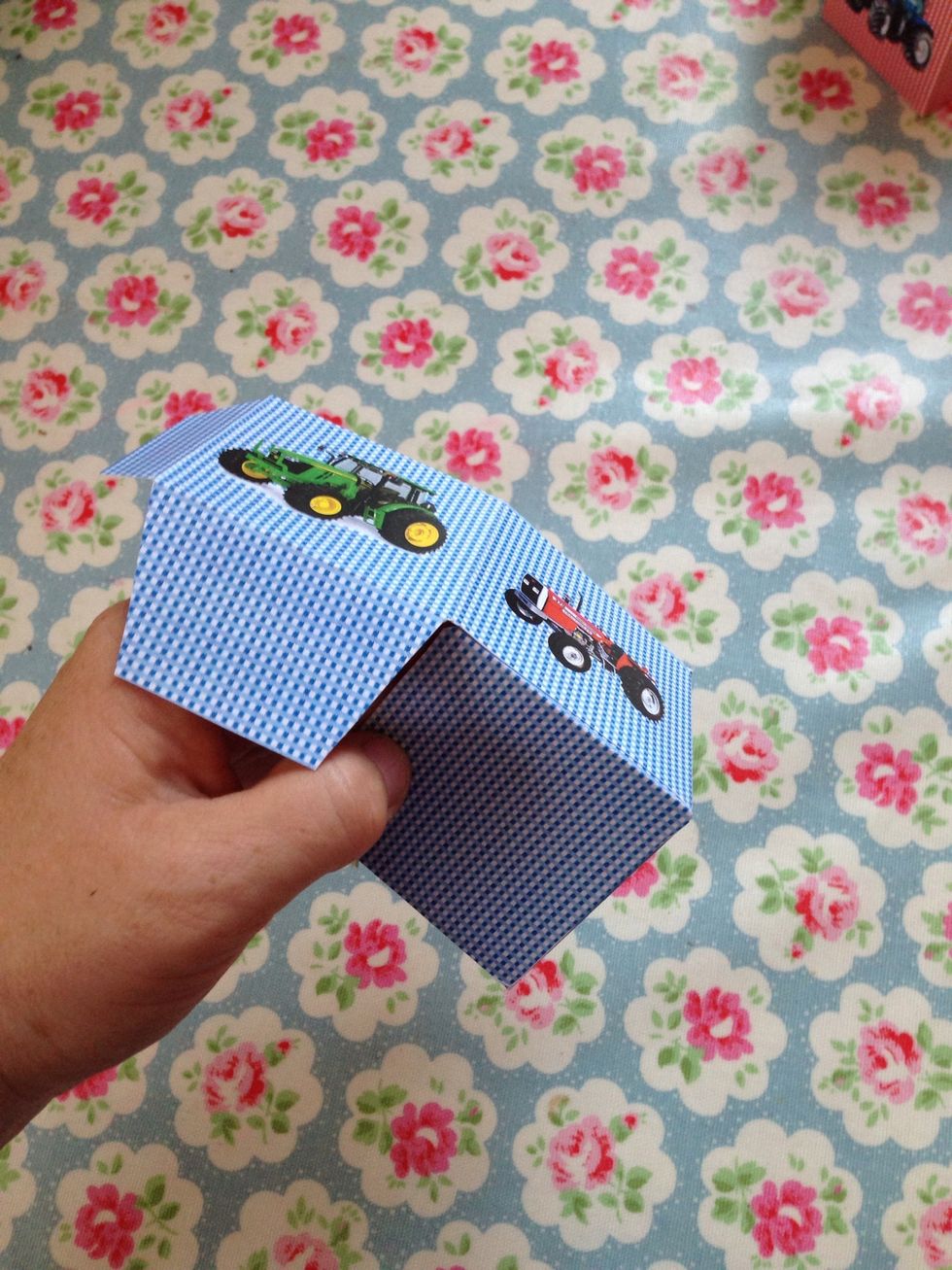 Turn the base and fold in the next large tab and press to stick to the base whilst at the same time lining up the side tab and sticking it in place.