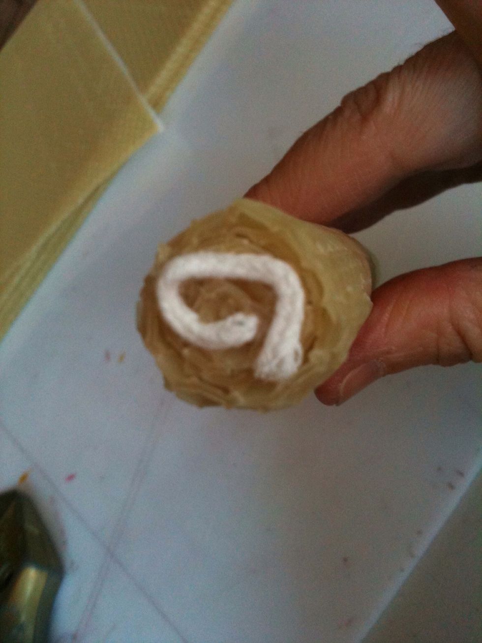 Turn the candle upside down, curl the bottom wick and press it tightly into the bottom of the candle.