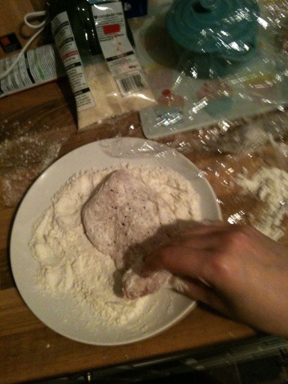 Turn the chicken escalopes one by one in the flour until fully coated.