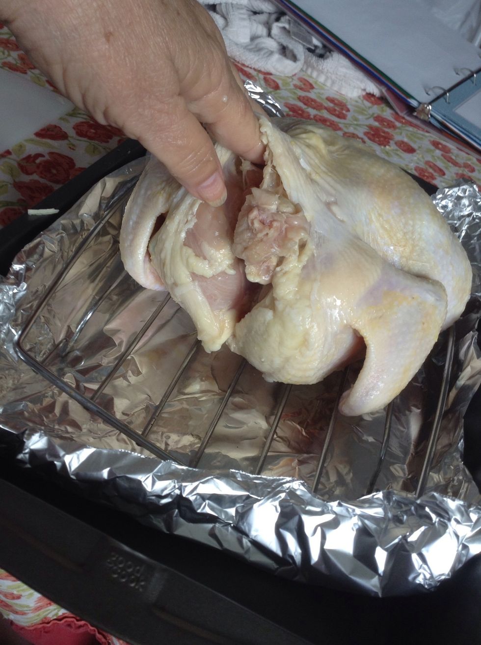 Turn the chicken over and repeat this process on the other side, separating the skin from the meat and inserting the fresh sprigs of rosemary and slices of garlic.