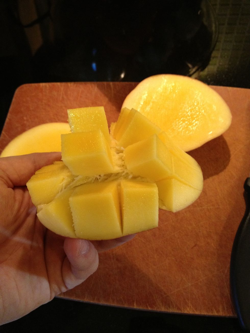 turn the half inside out so the fruit stick out in cubes. You can peel the cubes off with your hand or knife. Trim the remaining fruit off the seed.