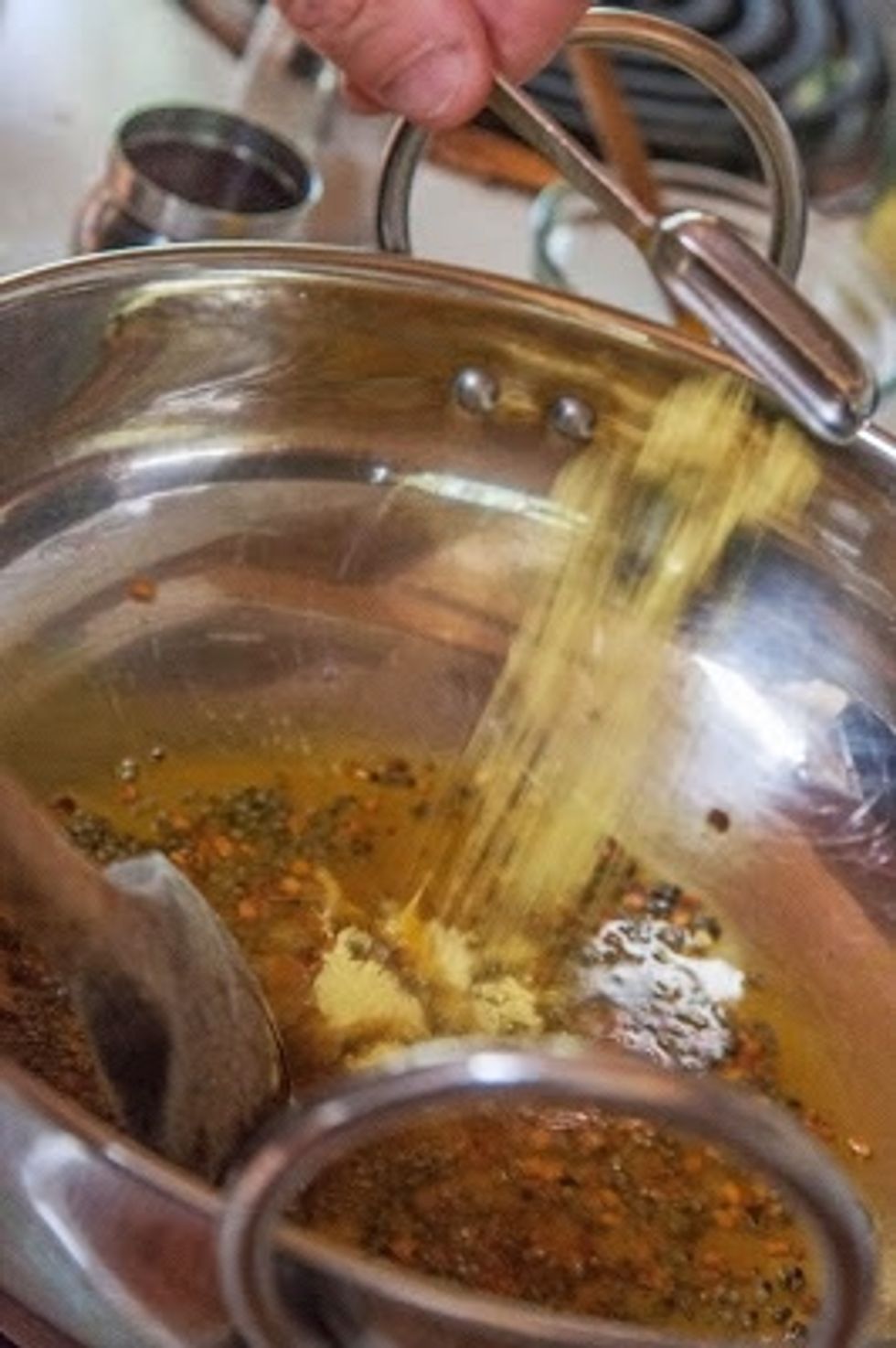 Turn the heat down and add in the turmeric, and asafoetida