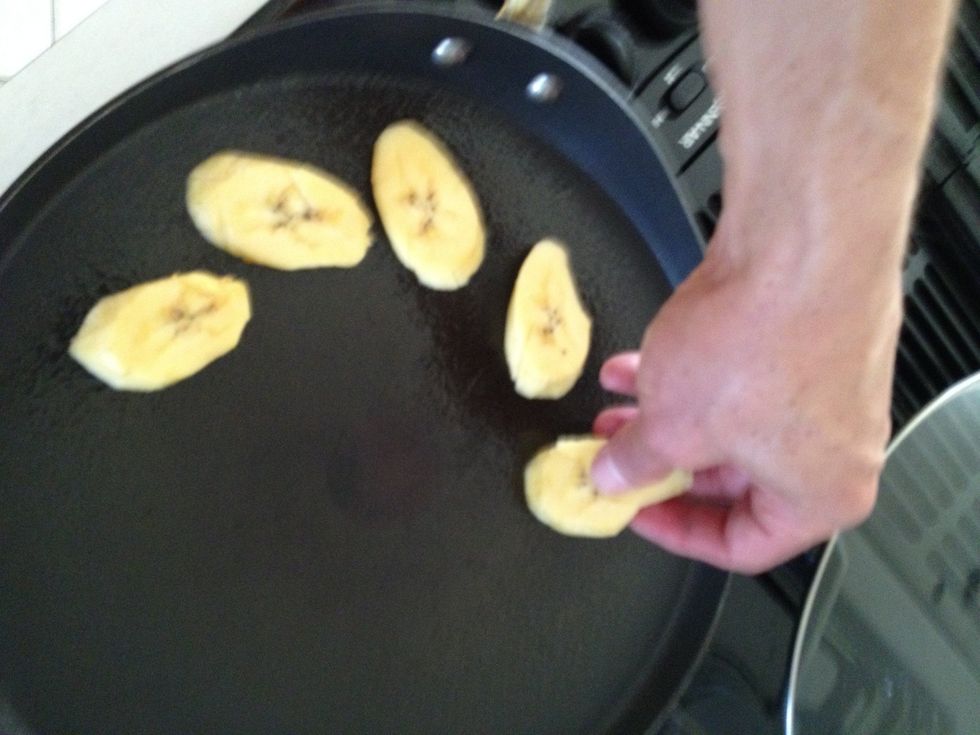 Turn the heat on medium heat. Place the sliced plantain pieces on the pan starting on the outside and working in toward the middle where the heat is to prevent the first pieces from burning.