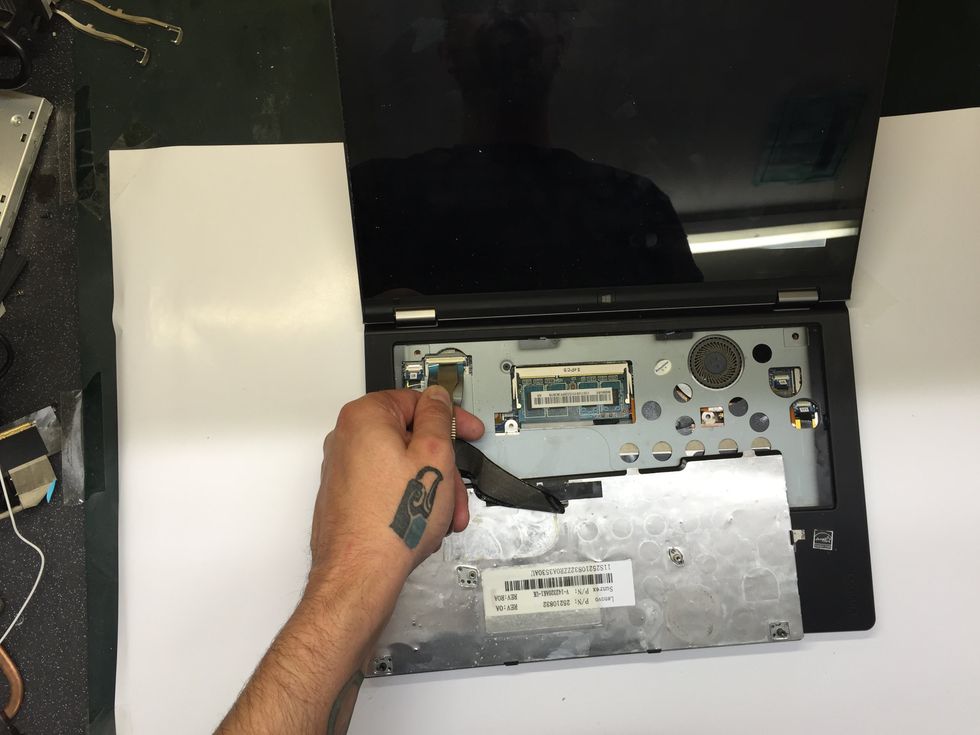 Turn the keyboard over and lay it keys down onto the palm rest. Follow the ribbon cable back to the upper left. Use the Spudger to lift the latch on the socket. BE VERY CAREFUL TO NOT DAMAGE IT!