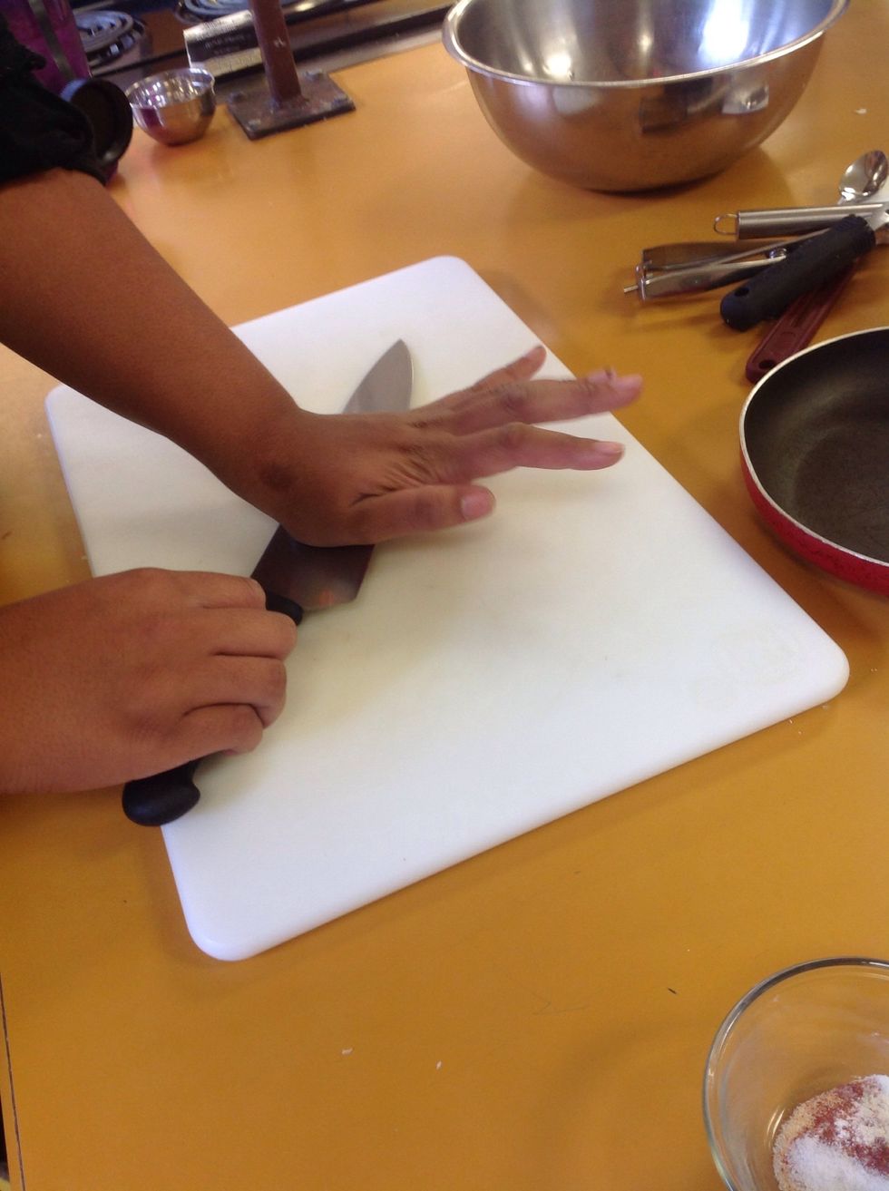 Turn the knife on its side and smash the garlic clove to remove the peel.