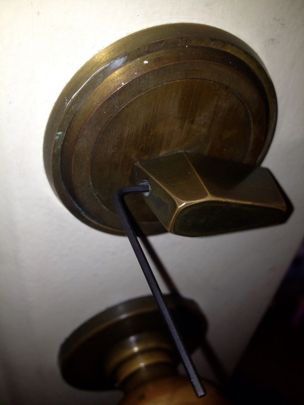 Turn the knob so that you get the most access to the set screw. This will probably slide the bolt do have the door open! Use the long end of the hex key for leverage and turn just enough to loosen.