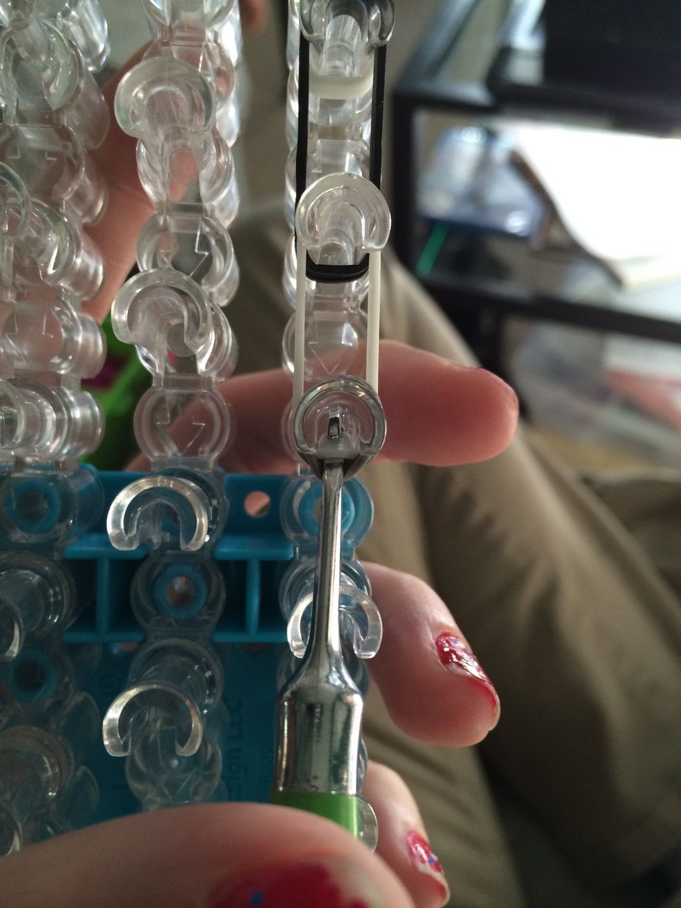 Turn the loom around. Reach in the last peg and grab the 3 white bands. If you don't get all three at once it's ok.