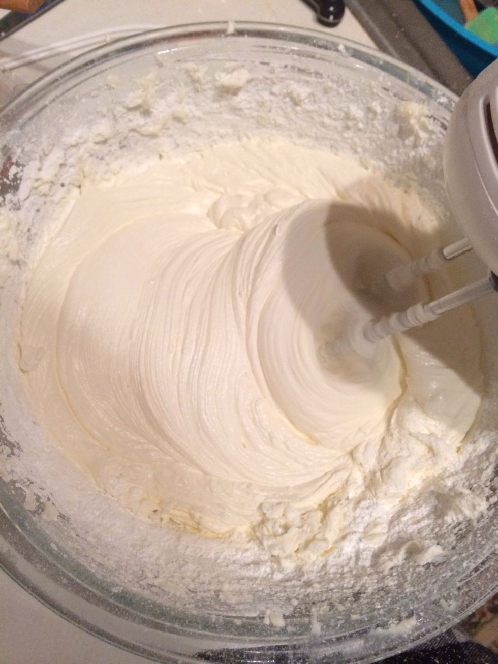 Turn the mixer down to low and gradually add in the confectioners' sugar until completely incorporated. Add in vanilla 3tbs of strawberry pur\u00e9e, mix until incorporated.