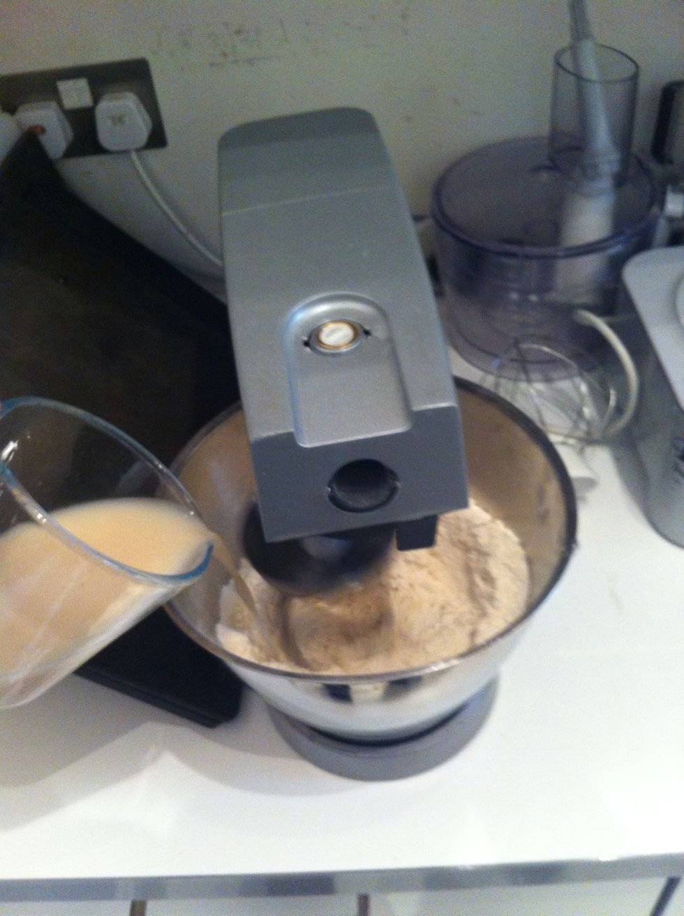 Turn the mixer on low and add the yeast and water mixture.if doing by hand just get then in there and mix!