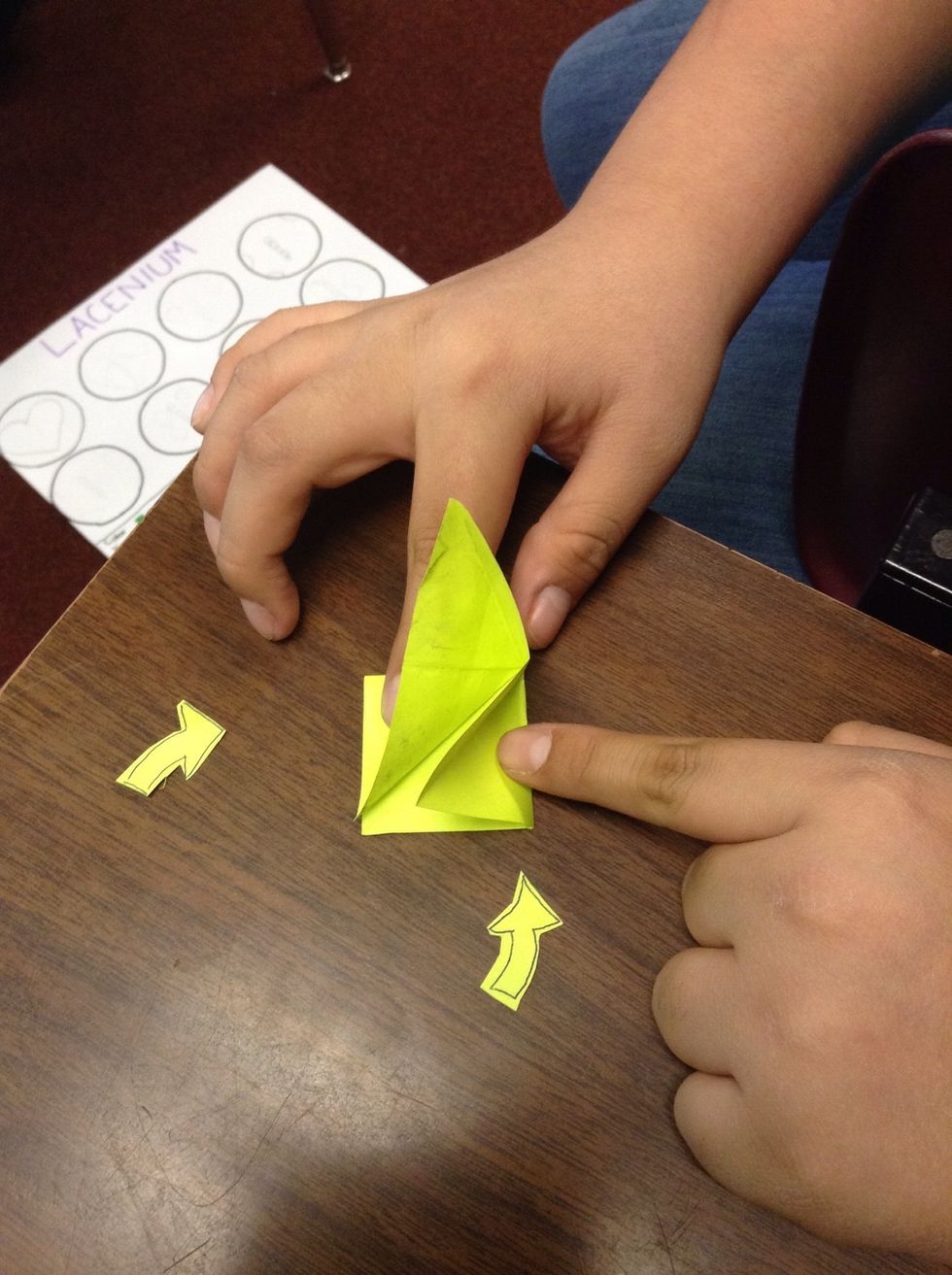 Turn the paper diagonal and take the two side squares and take each triangle side and push it down so that way the two triangle meet up with bottom square triangles and press the top down.