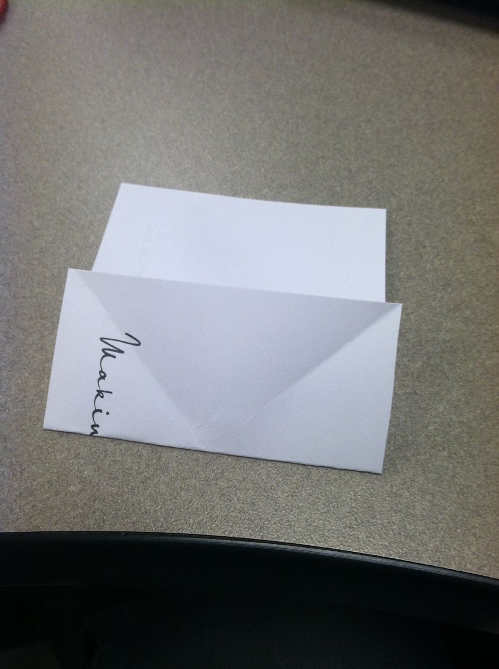 Turn the paper over so the x is on the bottom and fold back to crease the middle of the x.