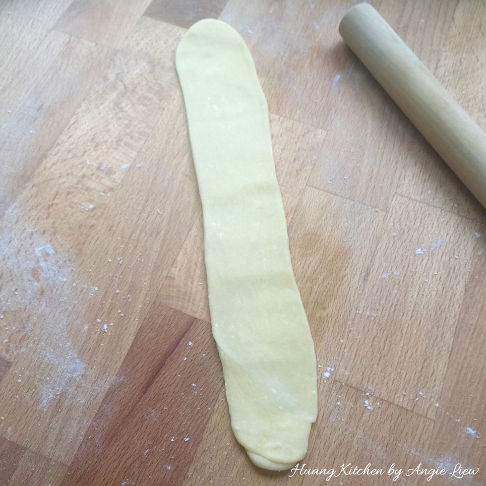 Turn the rolled dough upright. Flatten out the dough again into a long rectangular shape.