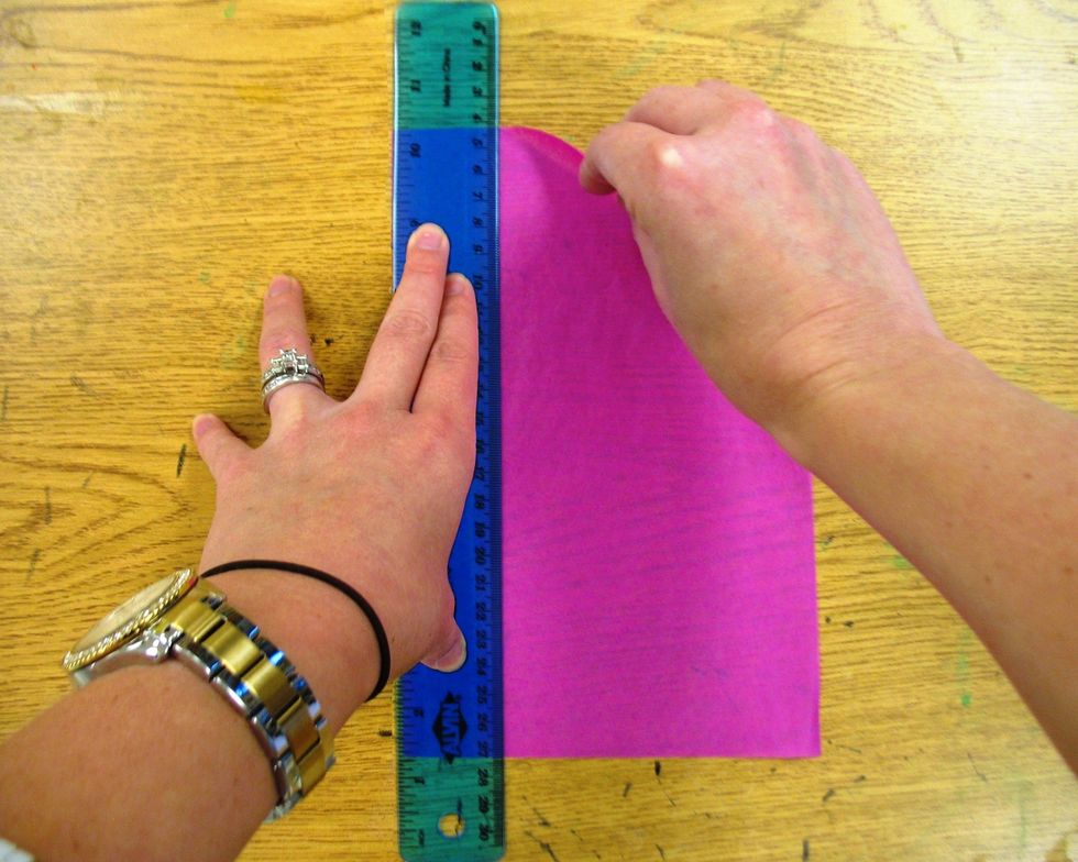 Turn tissue paper and ruler vertically. Place ruler on tissue paper. Hold ruler in place with your non-dominant hand. Tear downward along the ruler edge with dominant hand.