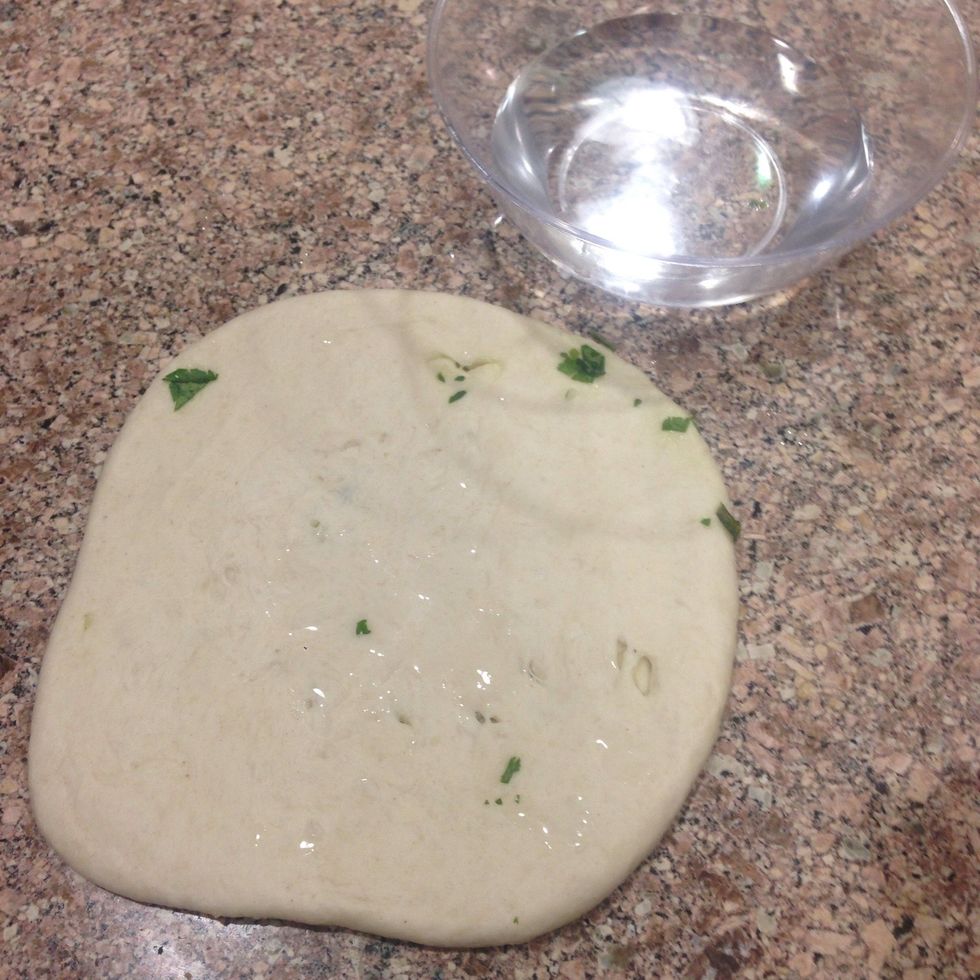 Turn to the other side and wet with water, this is step is necessary, in order for the naan to stick in the pan and not fall out.