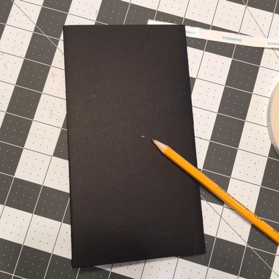Turn your booklet over with the back facing up.  Use a pencil to make a mark at the center which should be about 3 7/8" from top and bottom.