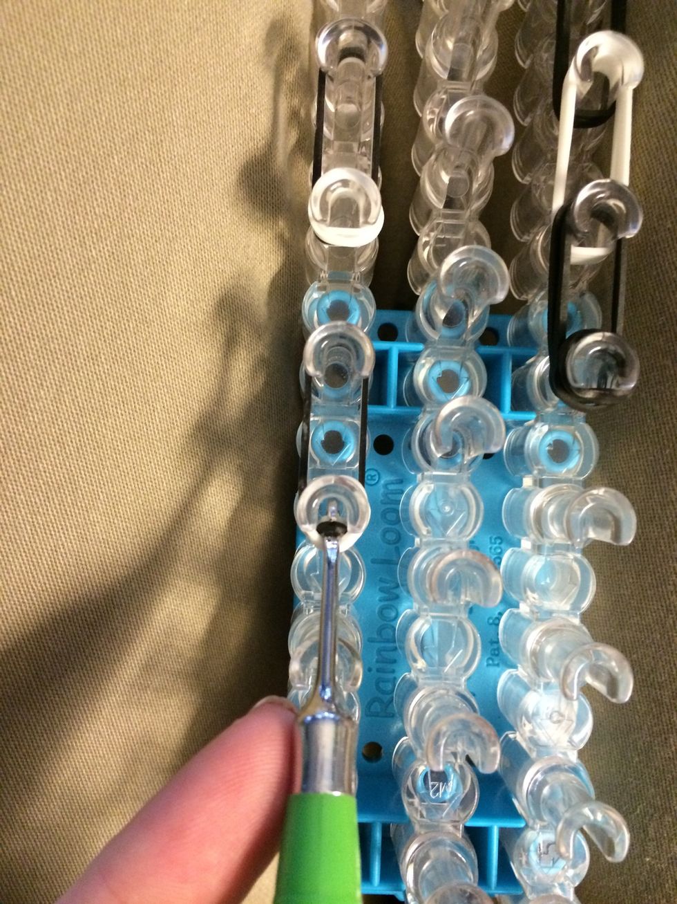 Turn your loom around and Reach in one of the ears and loop the two bands forward.