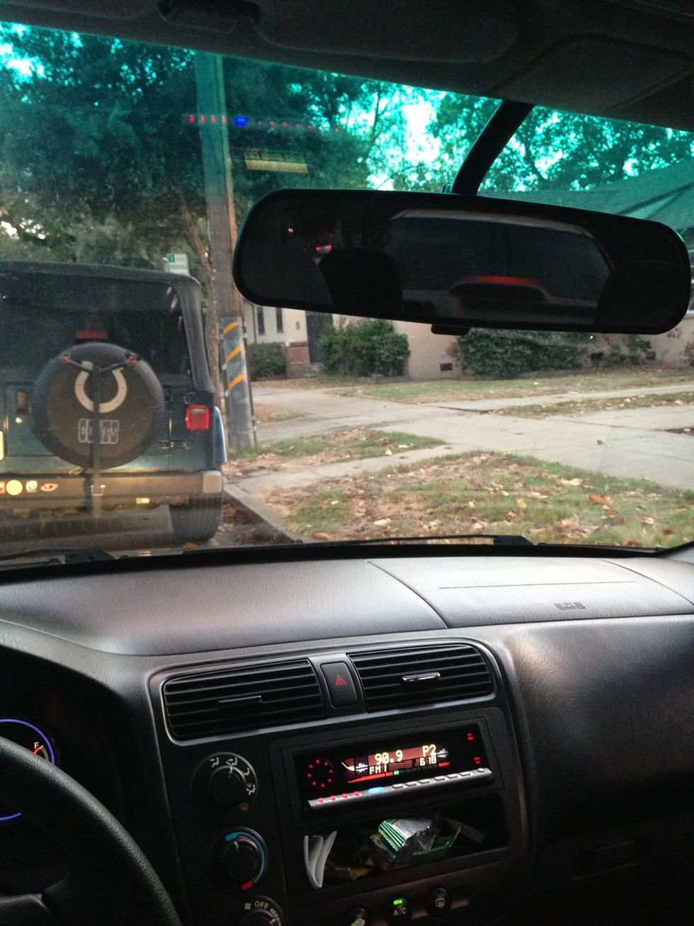 Turn your wheels almost entirely to the left, and slowly advance backward. Get as close to the rear vehicle as you can without bumping it. Go slowly. Inch by inch if needed. Watch the curb.