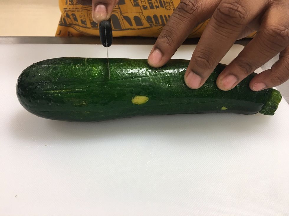 Turn your Zucchini horizontal, then place your knife on the Zucchini not to far away from the center but closest to the bottom of the Zucchini.