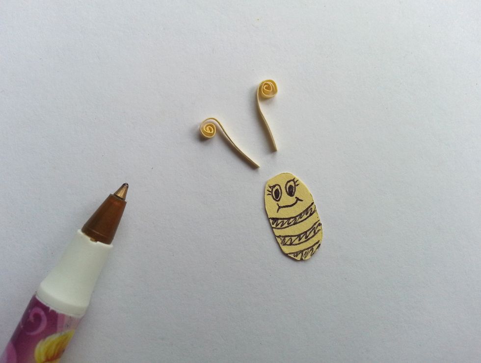Twirl the 2 thin paper pieces to make the antennas and draw a cute smiley face on the body part.