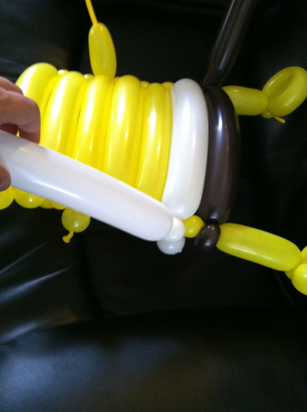 Twist a small bubble in the remaining white balloon and let the air out of the balloon above the twisted bubble. Tie off the remainder of the balloon.