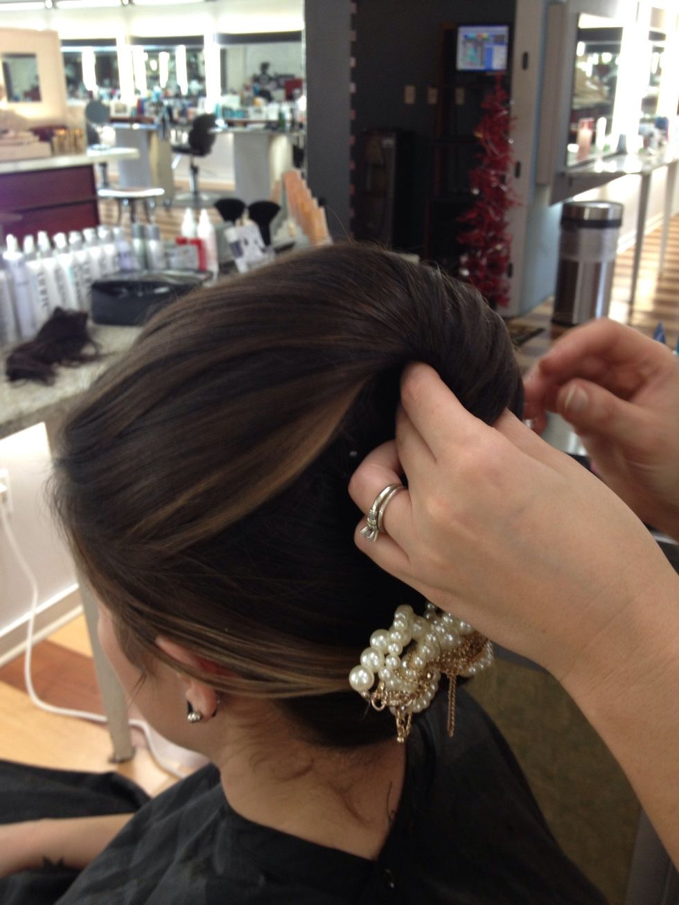 Twist back and pin to create a pompadour to add height and drama to overall look.