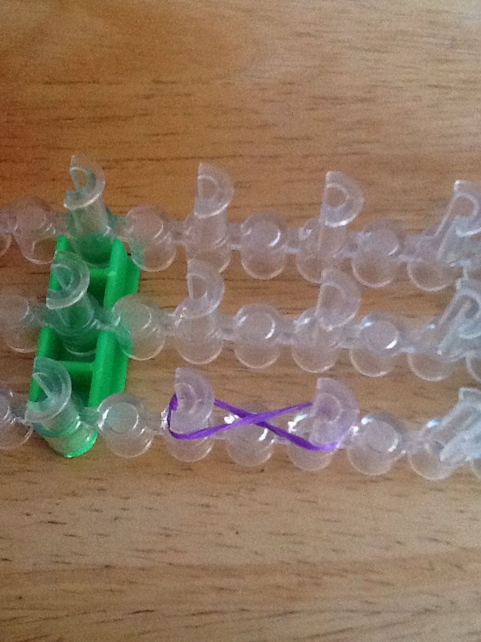 Twist the first rubber band on any 2 pegs on your loom.