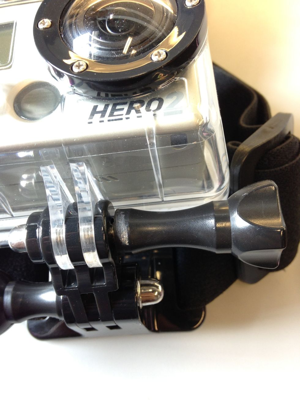 Twist the screw back in. Check the the camera case is securely fastened to the Head Mount.