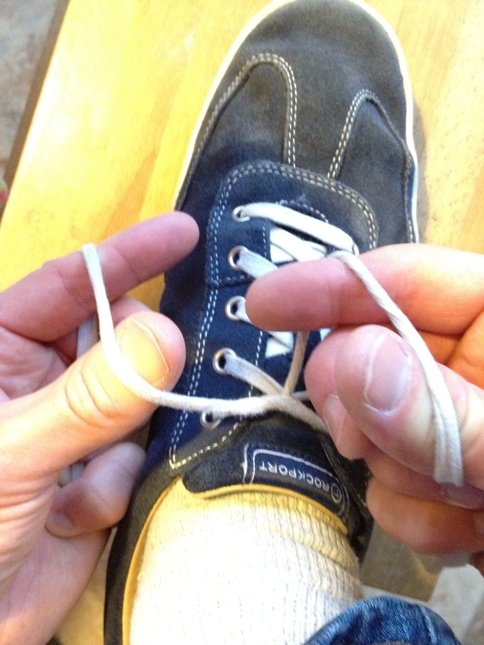 Twist your hands so the laces pass over the near side of your left thumb and far side of your right index finger.