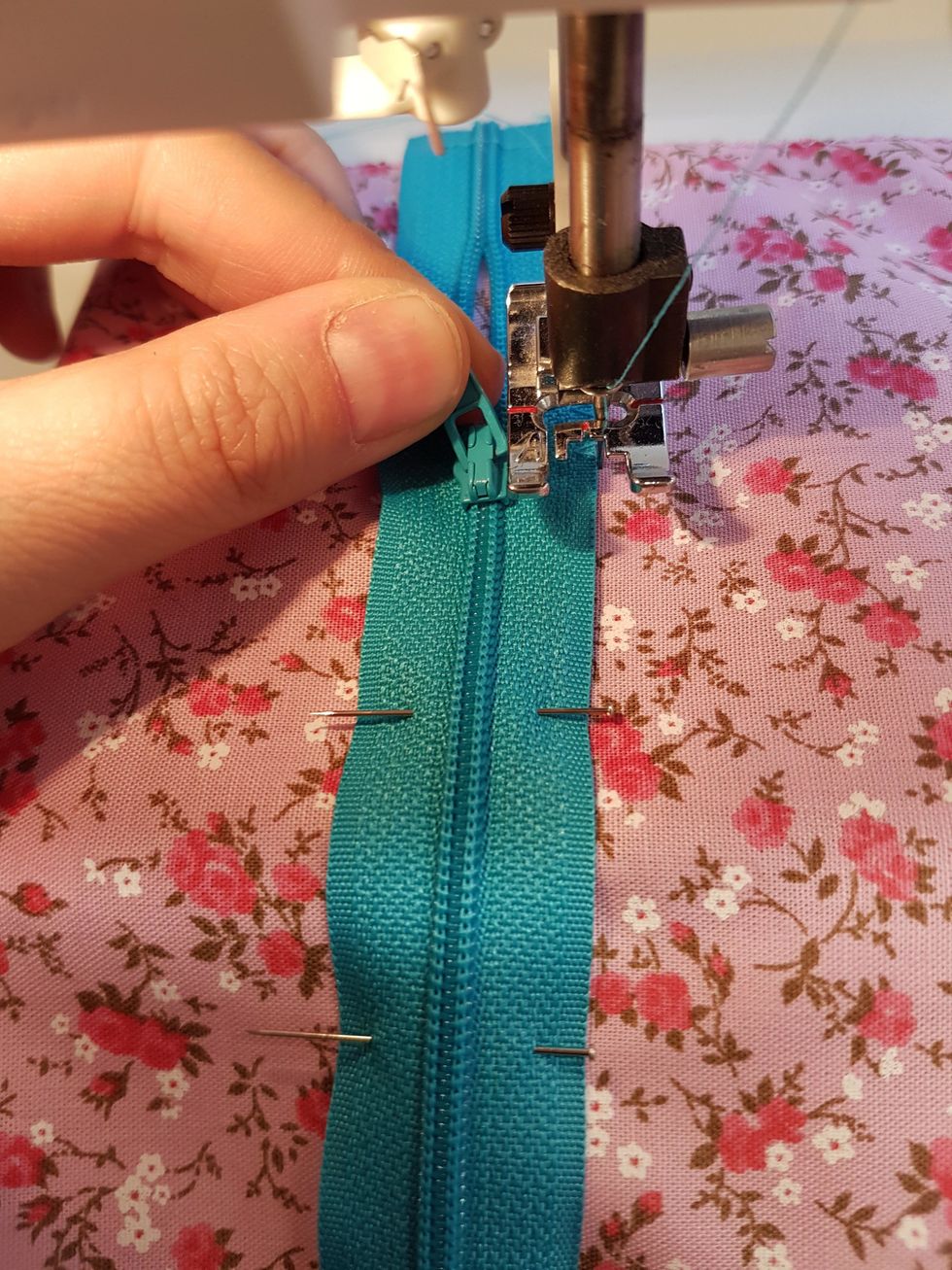 \u00c4r "ploppen" i v\u00e4gen, stanna med n\u00e5len nere. Lyft pressarfoten och \u00f6ppna eller st\u00e4ng dragkedjan.