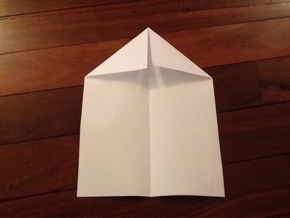 Un fold the paper and then fold the top of the paper down a little until a point appears.
