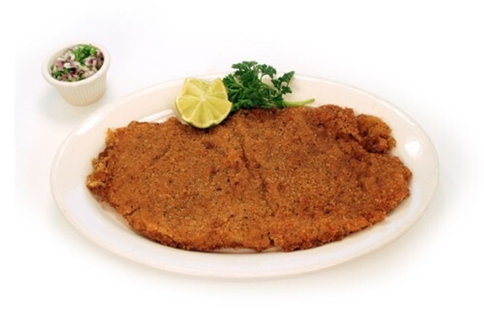 Un plato principal es bistec empanizada con arroz y ensalada.