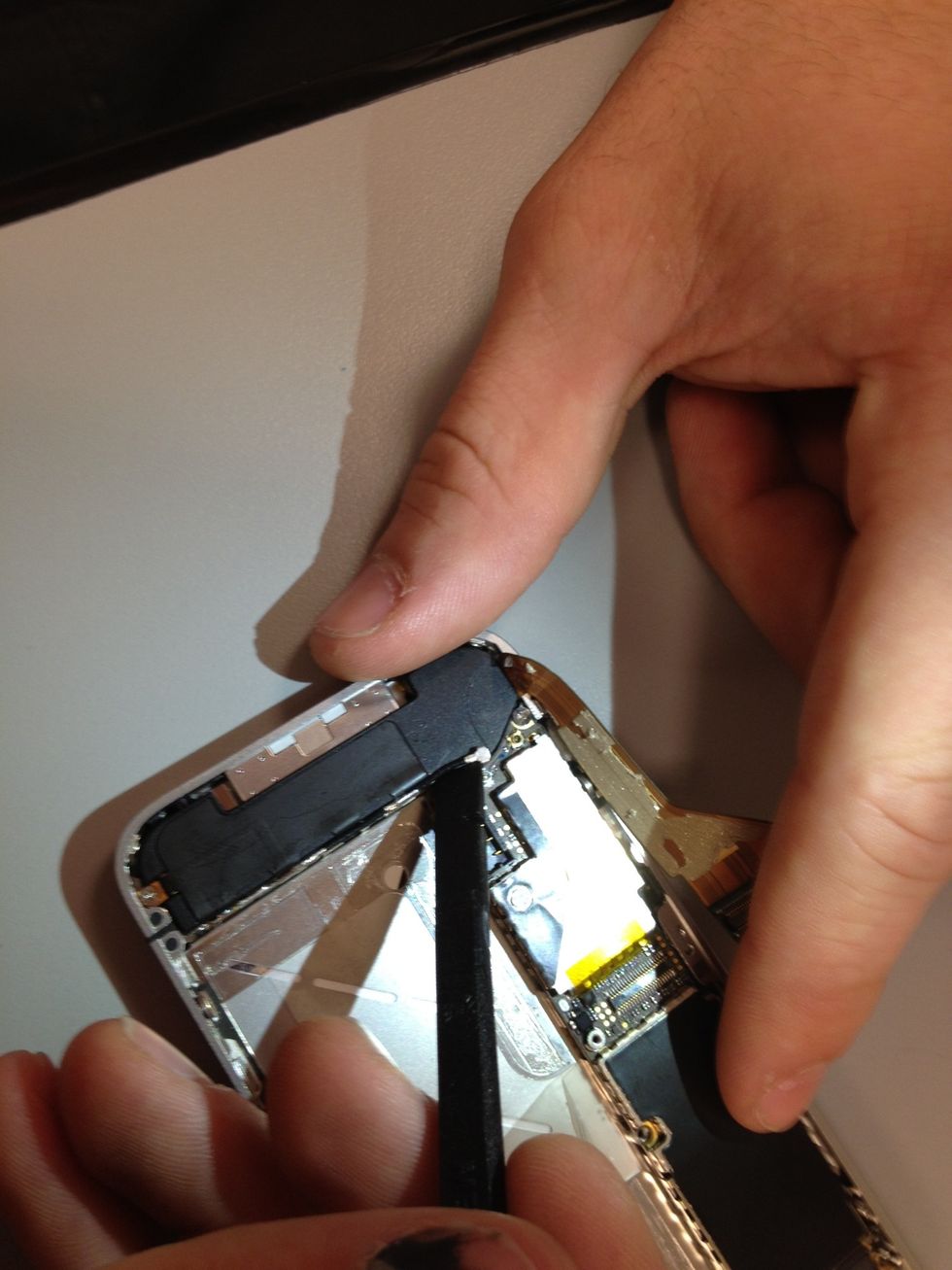 Underneath the dock ribbon connector lies the lower antenna plug, carefully pop it out of the socket.