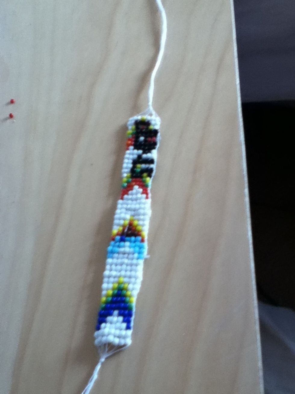 Undo the wooden cyclindes and remove your bracelet. Tie both ends as close to the design as possible.