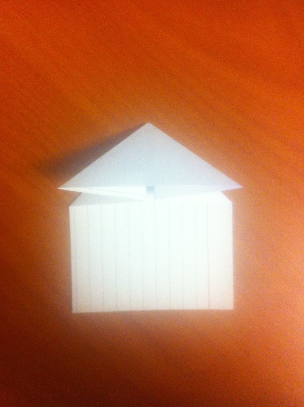 Unfold. Connect the two edges of the horizontal line, and put them down onto the card. This should bring the top of the card down to form a triangle (as shown).