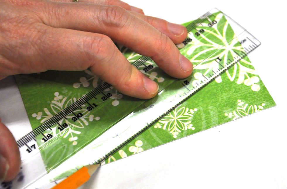 Unfold each piece, draw a line from the top centre point of the fold line down to the four inch mark near the bottom right corner.
