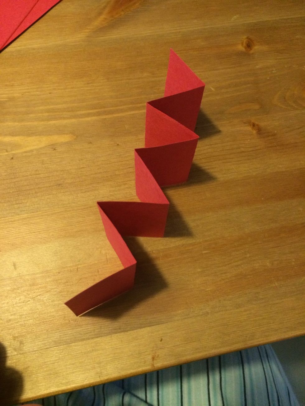 Unfold the paper and refold it so that it makes a zig zag accordion.