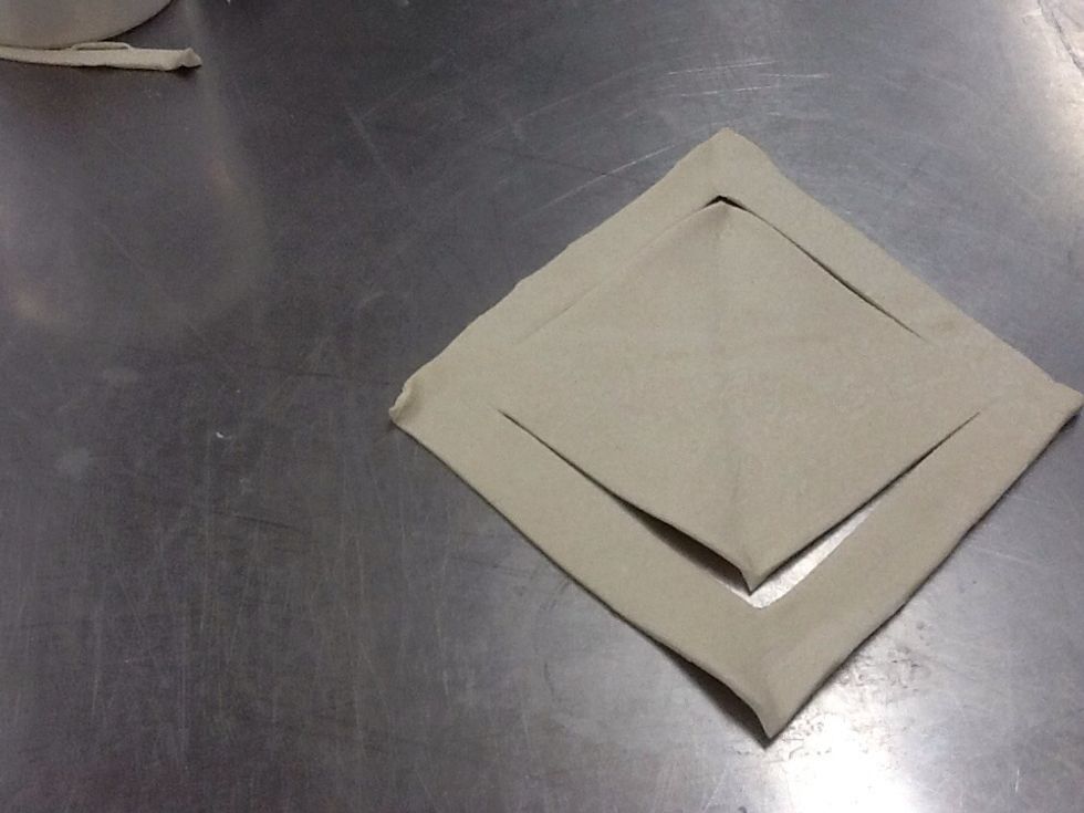 Unfold the triangle, the inner square should be attached to the larger square.