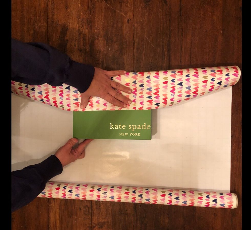 Unfold the wrapping paper and place the present in the center. Pull one end of the paper until it is at the middle of the present. Now measure the other end of the paper to the middle of the present.