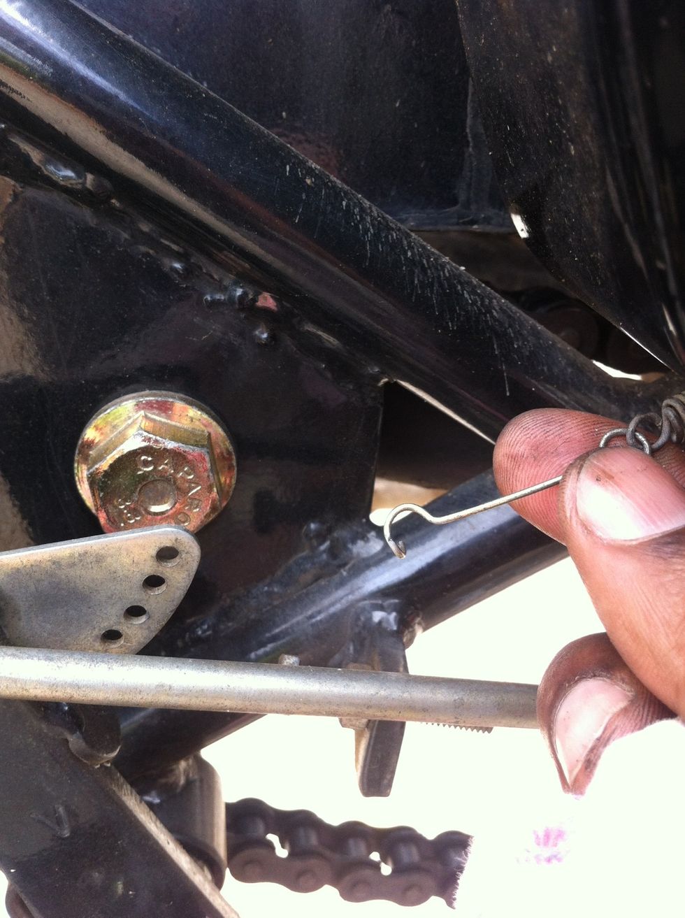 Unhook the brake light switch tension spring.